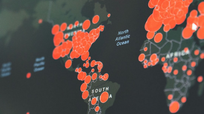 Des cercles rouges de différentes tailles sur la carte de l'Europe, de l'Afrique, des Amériques du Nord et du Sud indiquent où COVID-19 s'est propagé.