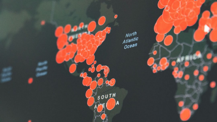 Los círculos rojos de varios tamaños en el mapa de Europa, África, América del Norte y del Sur indican dónde se ha extendido COVID-19.